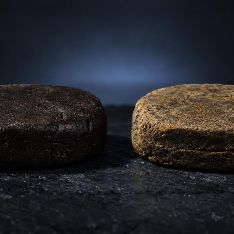 Twee compacte blokken hash, één donkerbruin en één lichtbruin, op donker oppervlak