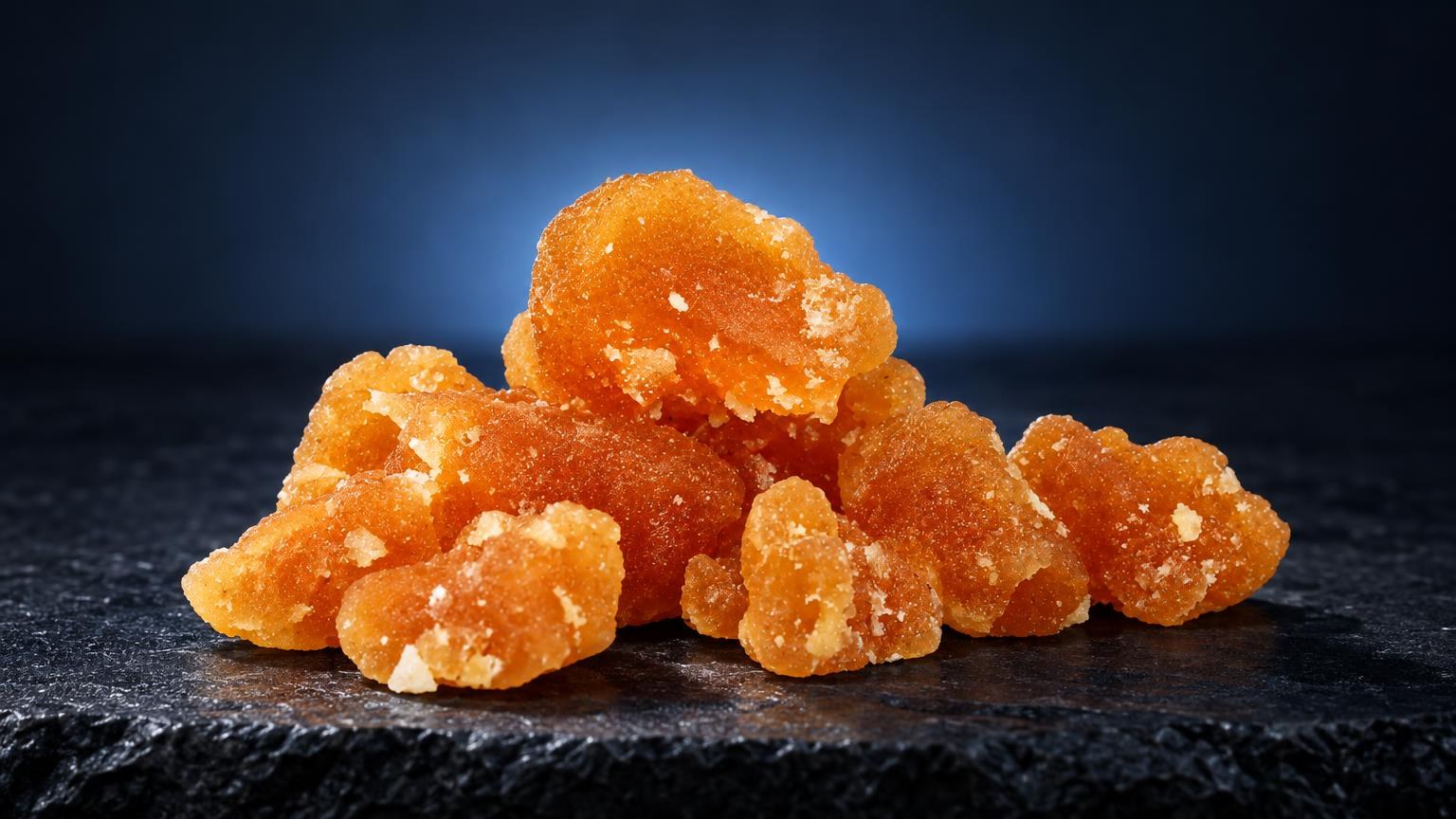 Cristal Bubble: amberachtige kristallijne korrels met glanzend oppervlak op donkere ondergrond, wat is rosin